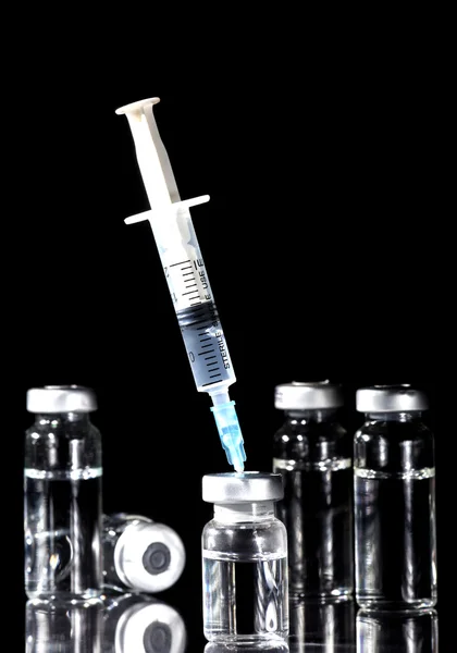 Glass Medicine Vials and Syringe on black background — Stock Photo, Image