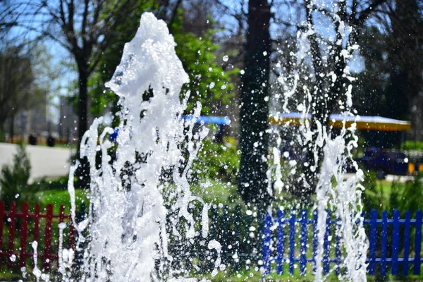 Fountain water sprinkles in a hot summer day — Stock Photo, Image