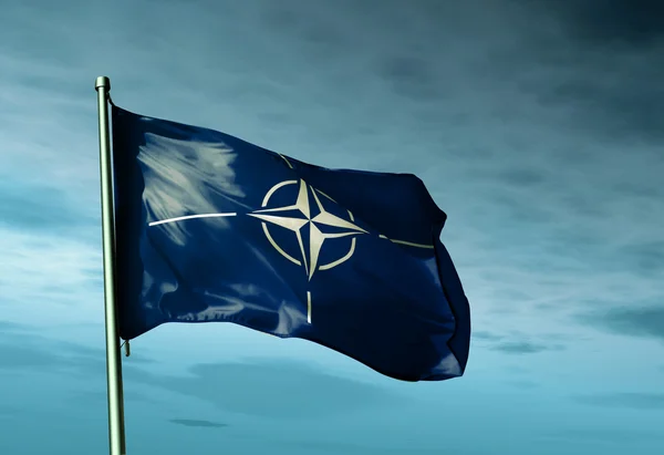 Nato の旗が風に手を振っています。 ストックフォト