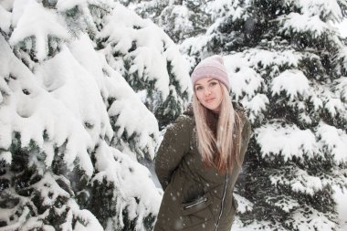 Ormanda, kışın yeşil ceketli güzel sarışın.