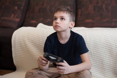 Avrupalı görünümlü bir çocuk oyun konsolu oynuyor