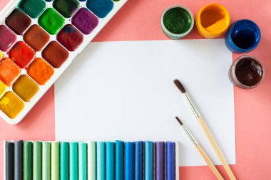 Beyaz arka planda boya fırçaları ve pasteller