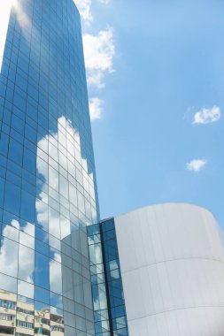 a building with a mirrored facade against a blue sky on a sunny day