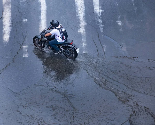 Motociclista Capacete Preto Monta Uma Motocicleta Preta Cruzamento Inundado Pela — Fotografia de Stock