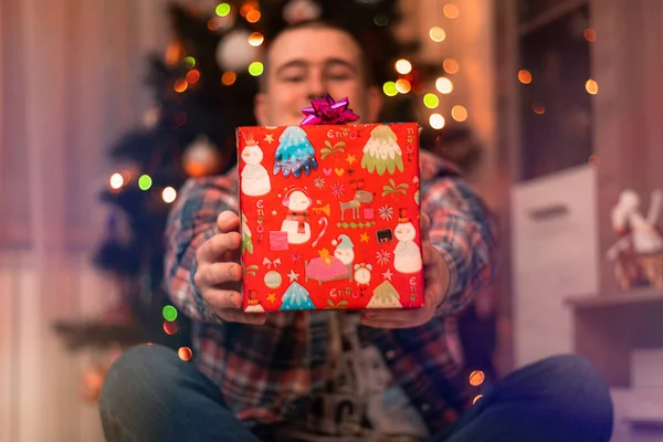 Jongeman Met Een Rode Geschenkdoos Zijn Handen Bij Kerstboom Het — Stockfoto