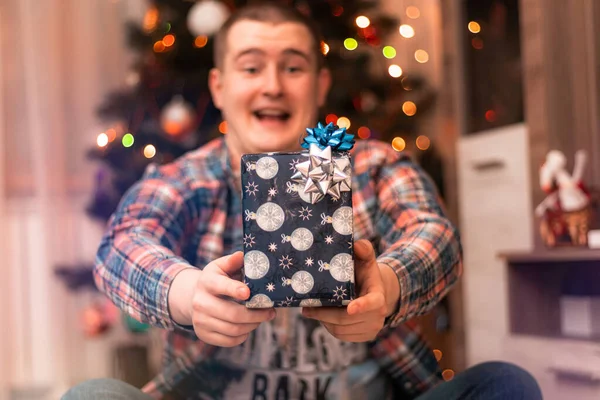 Mladý Muž Modrou Dárkovou Krabicí Rukou Vánočního Stromku Světly Chlapec — Stock fotografie