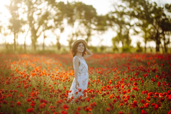 一个年轻的女人在春天的红罂粟地里玩的很开心 穿着白色浅色衣服的女孩享受着自由和好天气 春天和欢乐的概念 — 图库照片