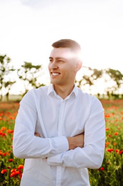 Haşhaş tarlasında duran genç bir adamın portresi. Güler yüzlü çocuk gün batımında kırmızı gelincik çiçekleri arasında özgürlüğünü hissediyor. Aşk, aile değeri ve barış kavramı