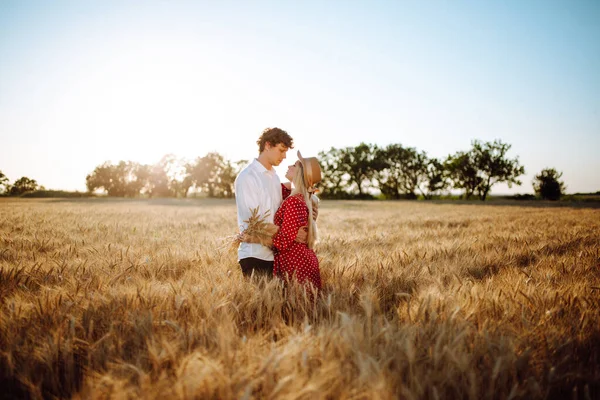 一对相爱的夫妇在麦田里摆姿势 日落时男人和女人的画像 夏天的风景暖色 爱情和生活方式的概念 — 图库照片