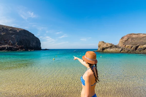 Jovem está apontando o horizonte em uma bela praia tropical — Fotografia de Stock