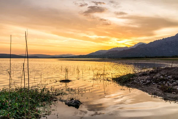 Colorful sunset reflected in the lake with the mountains at the background — Stock Photo, Image