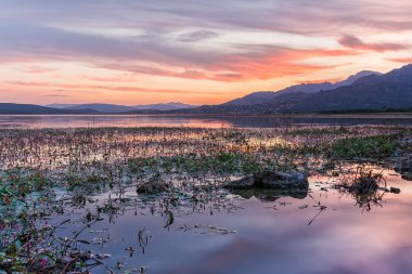 Arka plan, Dağları ile göle yansıyan renkli günbatımı