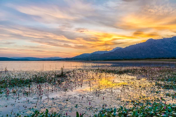 Colorful sunset reflected in the lake with the mountains at the background — Stock Photo, Image