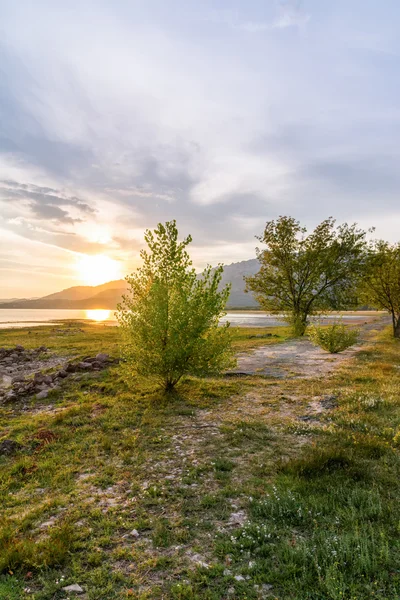 Beautiful sunset in the lake with the mountains at the background — Stock Photo, Image