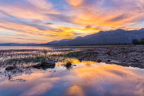 Colorful sunset reflected in the lake with the mountains at the background — Stock Photo, Image