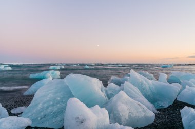Jokulsarlon, İzlanda gün batımında siyah bir plajda buzdağları