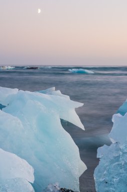 Jokulsarlon, İzlanda gün batımında siyah bir plajda buzdağları
