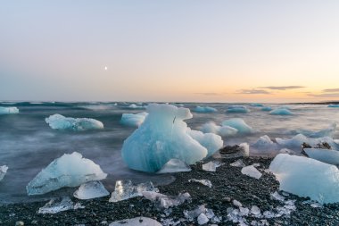 Jokulsarlon, İzlanda gün batımında siyah bir plajda buzdağları