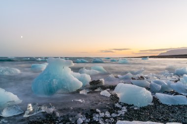 Jokulsarlon, İzlanda gün batımında siyah bir plajda buzdağları