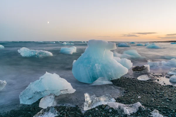 Jokulsarlon, İzlanda gün batımında siyah bir plajda buzdağları