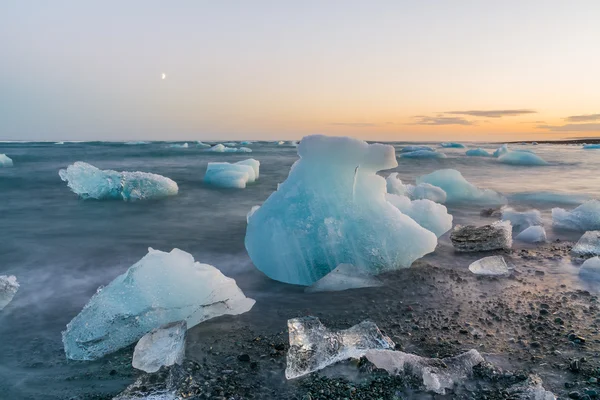 Jokulsarlon, İzlanda gün batımında siyah bir plajda buzdağları