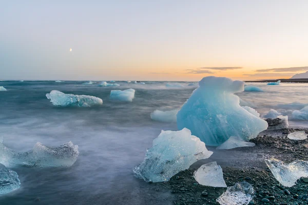 Icebergs em uma praia negra ao pôr do sol em Jokulsarlon, Islândia — Fotografia de Stock