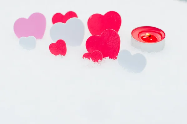 Rött, rosa och vita hjärtan och ljus i snön — Stockfoto