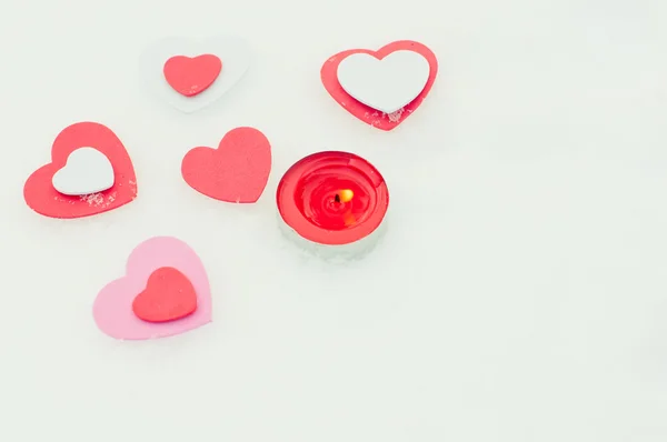 kırmızı, pembe ve beyaz kupa ve kar üzerinde mum