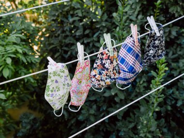 Bahçedeki çamaşır ipinde koronavirüsten korunmak için el yapımı yüz koruma maskeleri. Coronavirus konsepti