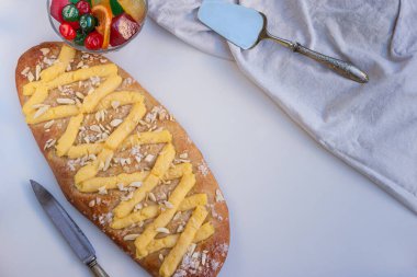 Vertical view of a coca de Sant Joan, a typical sweet flat cake from Catalonia, Spain, eaten at Saint Johns Eve, on a white background. clipart