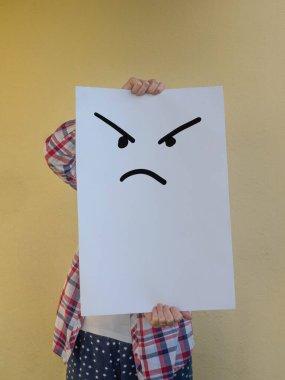 Boş bir reklam panosunun arkasında suratını saklayan sıradan bir kadın. Boşluğu kopyala