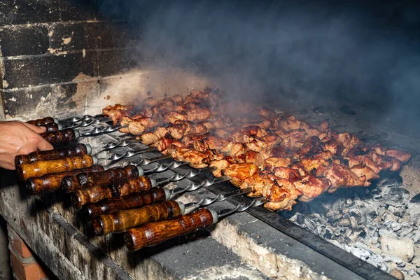 Barbekü. Salamura kebap. Metal bir şişte ızgara et. Beyaz duman yaklaşıyor. Dikkati dağılmış. Kızarmış domuz etli adam..
