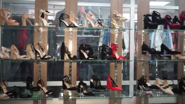 Dames schoenen en sandalen op glazen planken in de winkel — Stockvideo