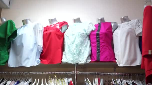 Vrouwen blouses op mannequins en jurk op hangers in de winkel op de vitrine — Stockvideo