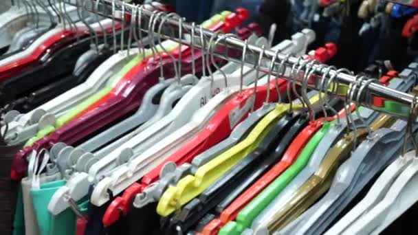 Perchas multicolores con ropa de mujer en la tienda — Vídeos de Stock