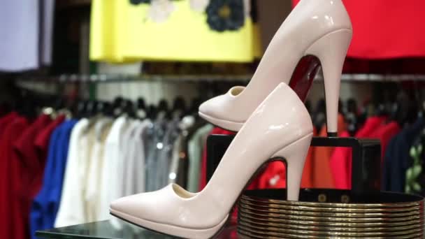 Mağazadaki Çeşitli Kadın Kıyafetlerinin Arka Planında Yüksek Topuklu Kadın Ayakkabıları — Stok video