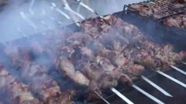 Izgarada, şef kebabı ters çevirerek kızartıyor. Kapat.