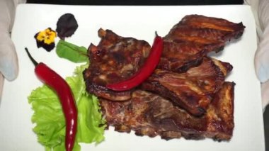 Aşçı kırmızı biberli pirzola gösteriyor.