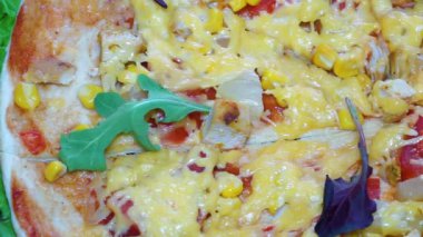 Domatesli, etli, mısırlı, pastırmalı ve kalın peynirli lezzetli pizza. Kamera hareketi soldan sağa