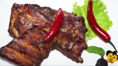 Kızarmış kaburga ve kırmızı biber beyaz tabakta.