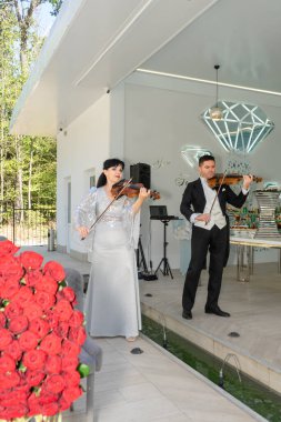 Kemancı ve kemancı aristokrat bir tatilde keman çalar.