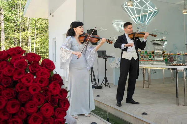 바이올린 연주자 바이올린 연주자인 사람은 귀족의 축일에 장미가 커다란 꽃다발을 — 스톡 사진