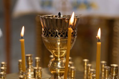 Altın mum tutacağı titreyen mumlar sergiliyor. Ruhani bir anda sıcak ve huzurlu bir atmosfer yaratıyor..