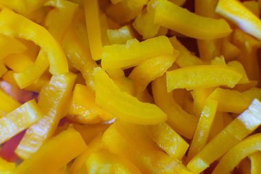 Taze kesilmiş sarı dolma biber şeritleri lezzetli bir salatada ya da kızartmada kullanılmaya hazır olarak yan yana otururlar..