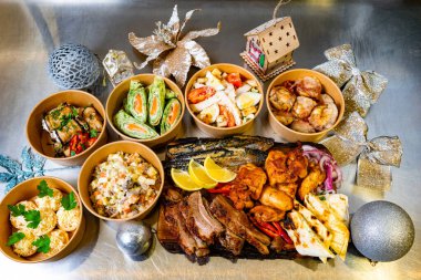 Etli yemekler, salatalar ve çeşitli aperatifler içeren renkli bir ziyafet. Kutlama için zarif bir şekilde düzenlenmiştir..