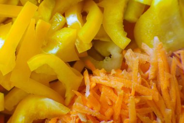 Parlak sarı dolma biber ve ince doğranmış havuçlar bir araya getirilir, sağlıklı yemek hazırlığı için idealdir. Taze malzemeler kullanıma hazır..