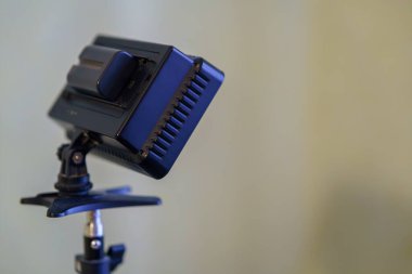 Küçük bir stüdyo ışığı, fotoğraf çekiminde kullanılmak üzere bir standın üzerine dikkatlice yerleştirilir. Arka plan yumuşak ve sessiz..