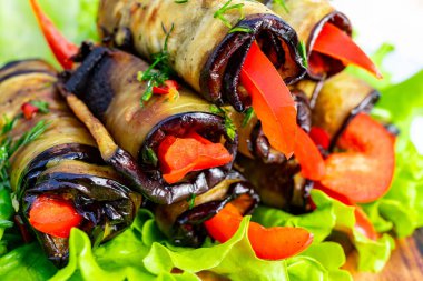 Sebzeli dürümler ahşap bir tabakta kırmızı biberle hazırlanır ve marul yatağında servis edilir..