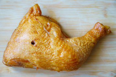 Kızarmış tavuk budu mutfaktaki ahşap bir kesme tahtasına yerleştirilir. Öğle yemeği vakti geldi ve sahne çok basit..