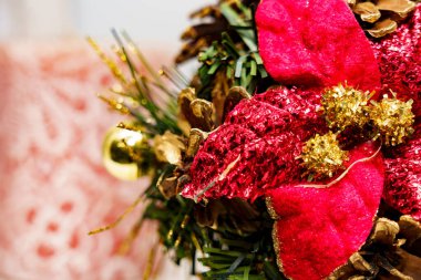 Parlak kırmızı çiçekler ve yeşil çam dalları bir evde neşeli bir görünüm oluşturur. Tatil ruhu anlaşmada açıkça görülüyor..